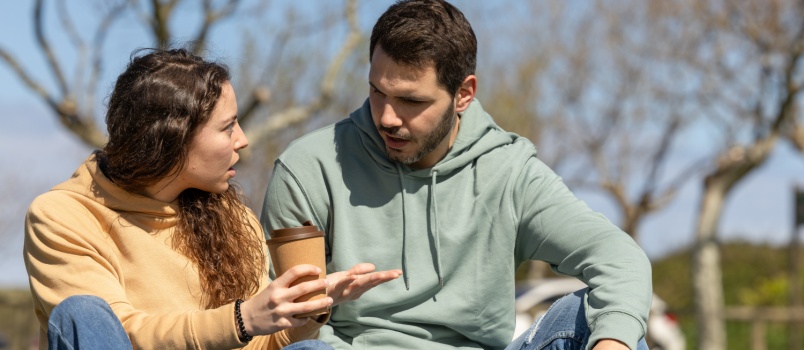 Couple sitting in park talking to each other