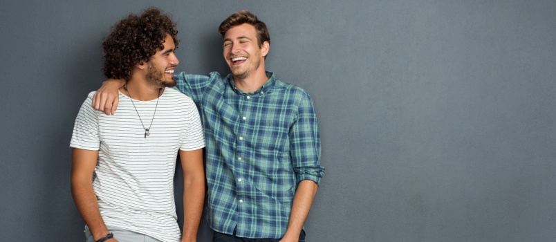 Two male best friends standing and laughing