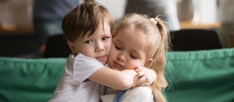 Little brother hugging upset sister 