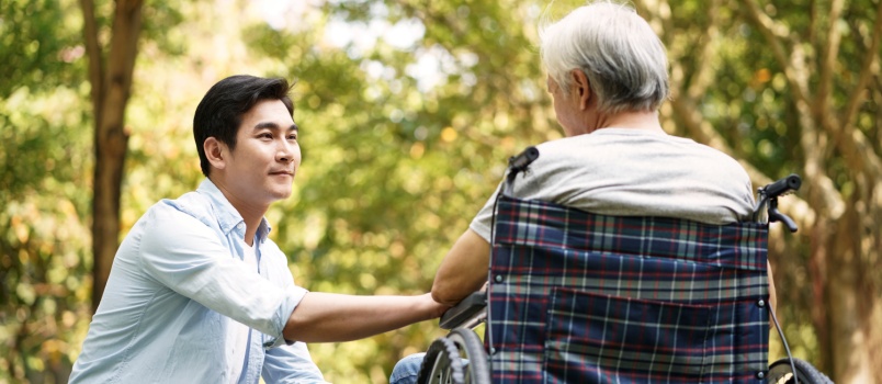 Man talking to old man sitting on wheelchair