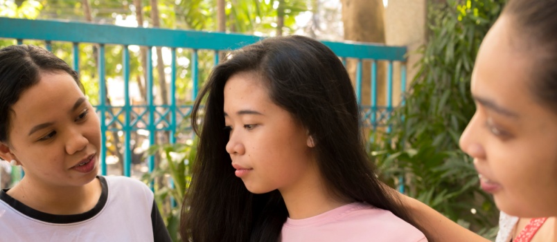 friends comforting teenager