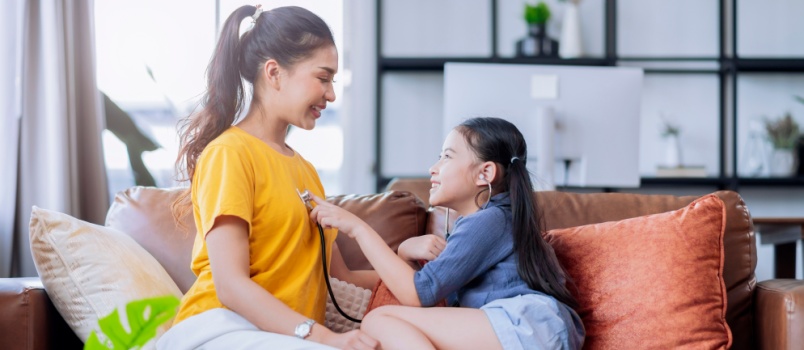 Daughter playing doctor with her mother