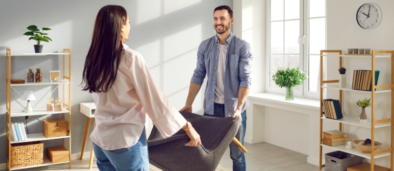 Young couple carrying armchair