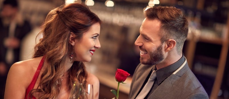 Man giving rose to attractive lady