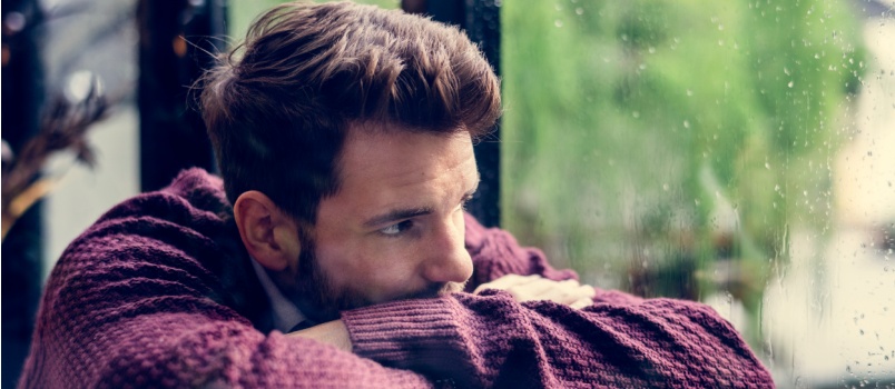 Thoughtful man looking out of window 