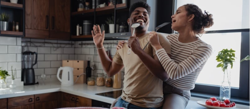 Happy playful couple cooking together