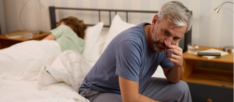Worried man sitting on bed