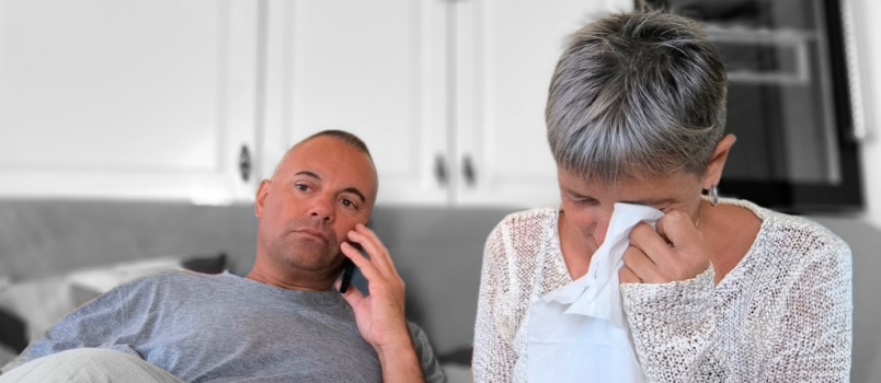 Man talking on phone while woman is crying