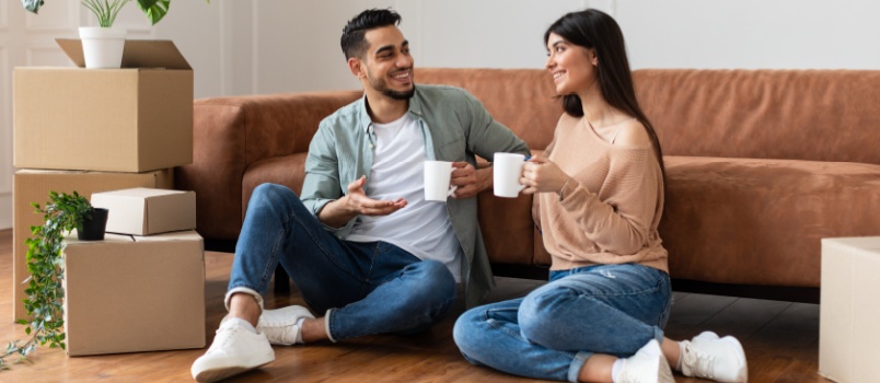 Young couple sitting on couch having coffee