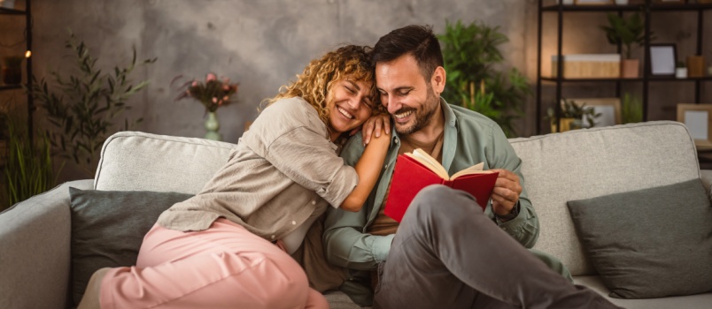 Man reading book while his girlfriend relaxing
