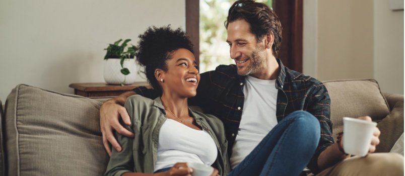 Couple sitting on couch having coffee