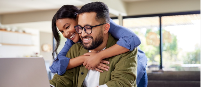 Happy couple using laptop