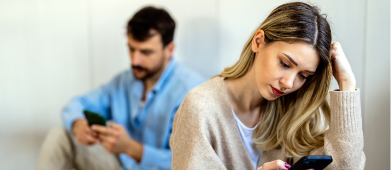 Couple sitting back focused in phone