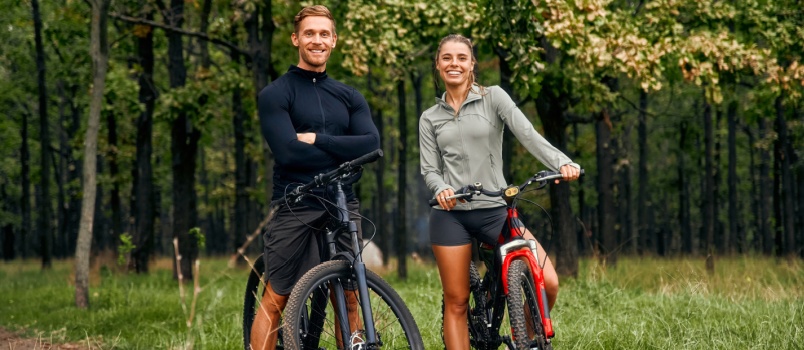 Cherful couple bicycling in mountains
