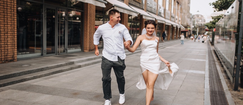 wedding couple running on street