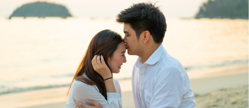 Man kissing on woman forhead