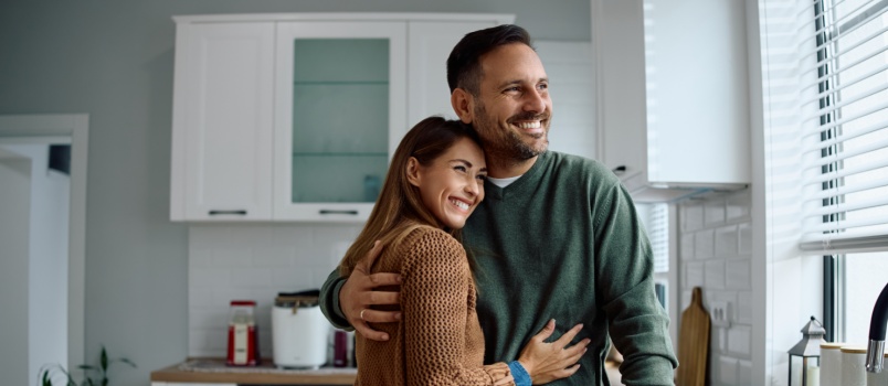 Young loving couple embracing each other in kitchen