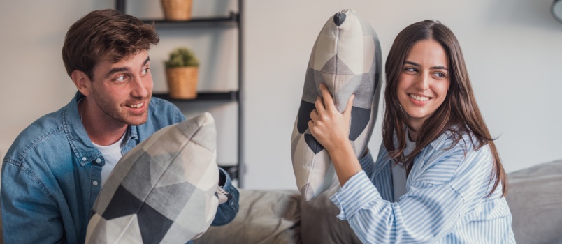 Couple laugh during pillow fight