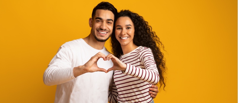 Joven pareja haciendo corazón con su mano