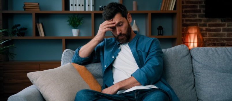 tired upset man sitting on couch