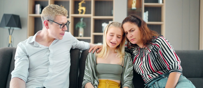 Les parents réconfortent leur fille triste et déprimée