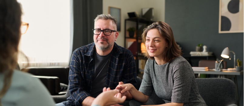 Couple sitting close listening to counselor