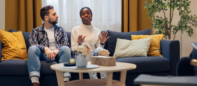 couple sitting on couch having discussion