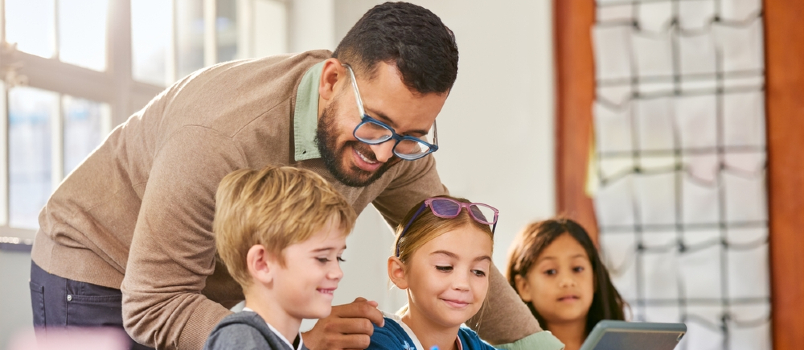 Male teacher helping school children