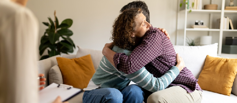 couple hugging each other in therapist office