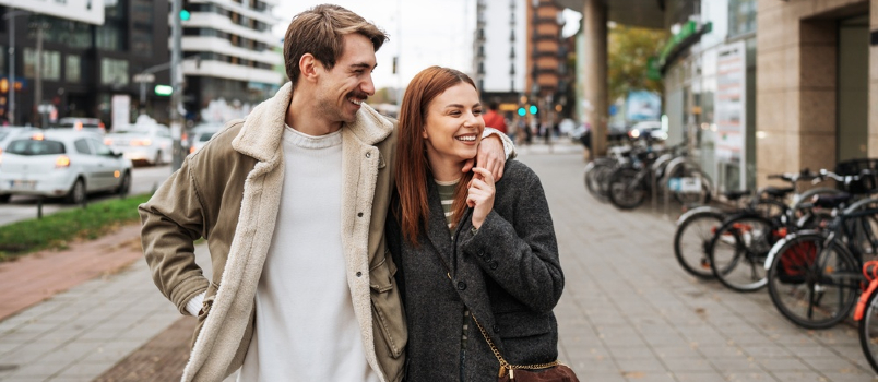 Couple souriant marchant dans la ville