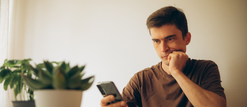 Man with Brown Hair Looking at Phone Indoors 