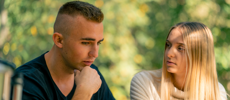 Concerned Woman Comforts Unhappy Man in Nature