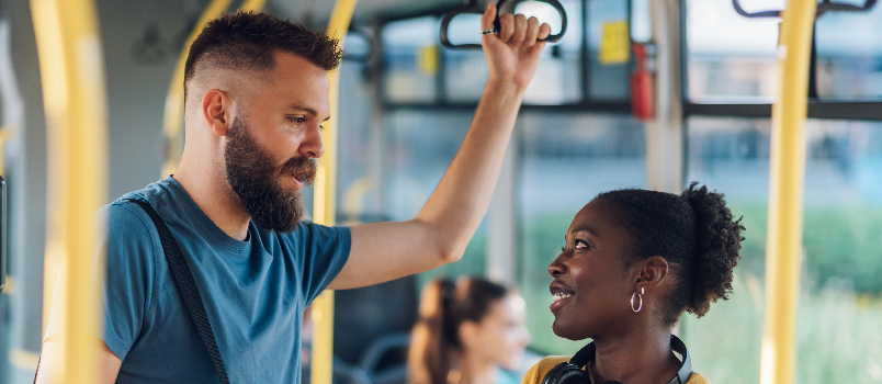 Smiling Woman and Bearded Man Talking on Bus
