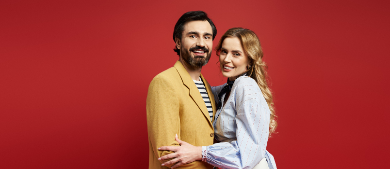 Couple embracing infront of red wall