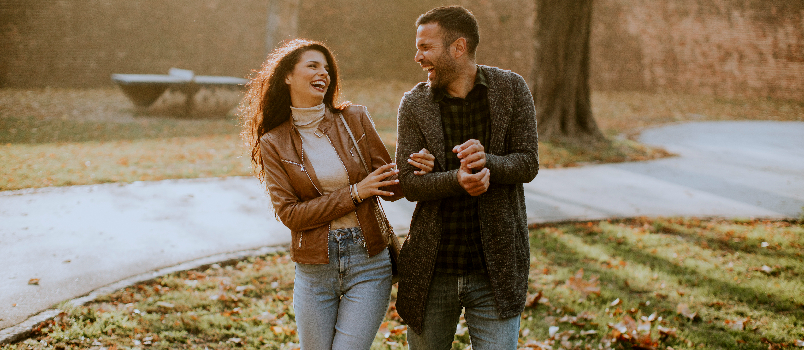 Smiling Couple Walking in a Park on Autumn Day