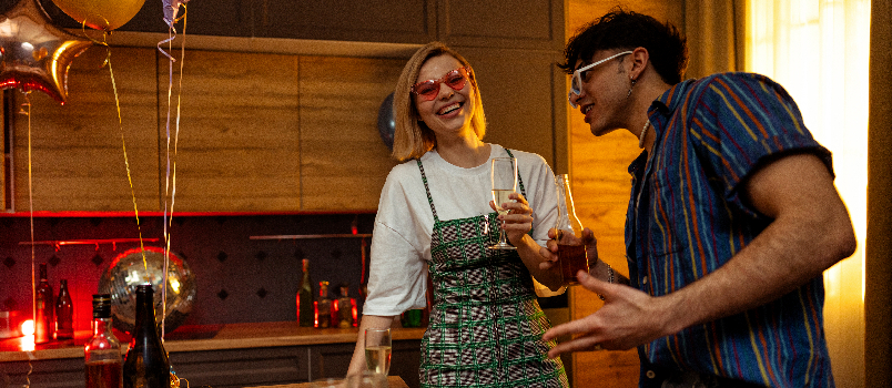 Two Young Adults Celebrating with Drinks in Home