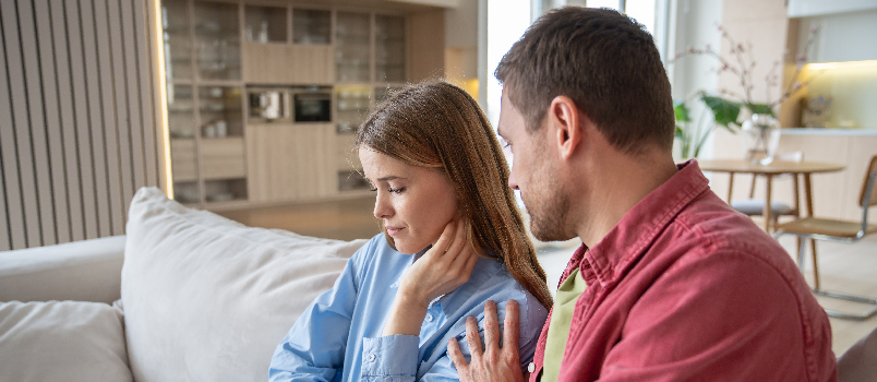 Upset Woman Comforted by Partner on Sofa