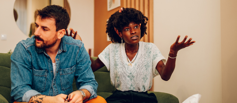 Upset Couple Sitting on Couch Indoors