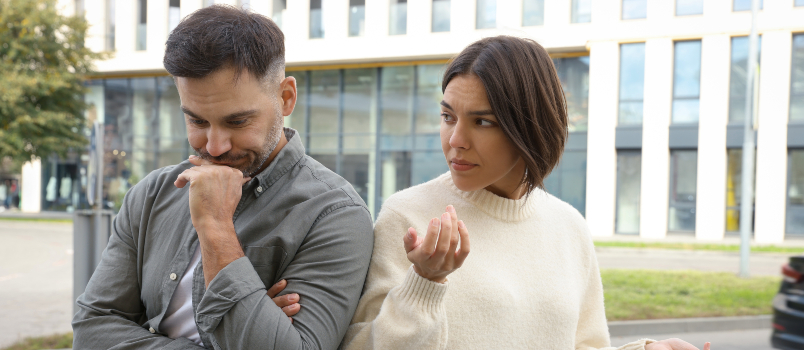 Man and Woman Standing Back-to-Back in City