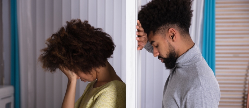 Side View Of Young Unhappy Couple Standing Back To Back At Home