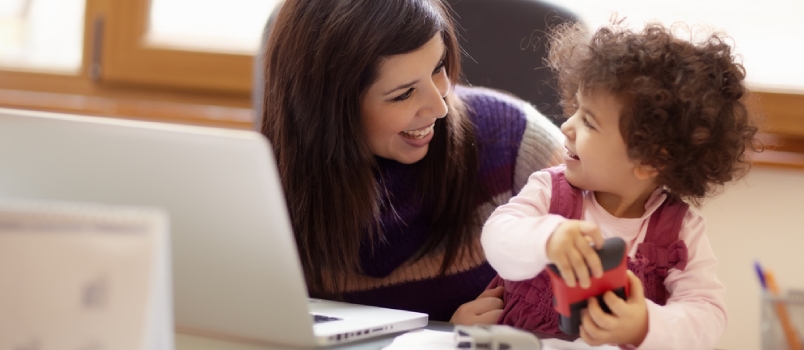 Mom Working With Laptop Computer at Home and Playing With Her Baby Girl